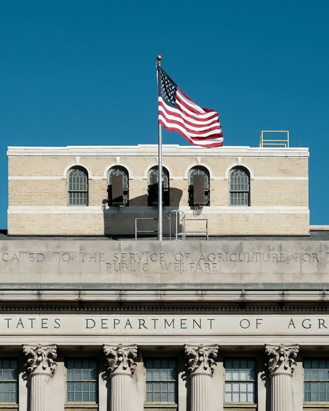 The United States Department of Agriculture building with the American flag flying above it