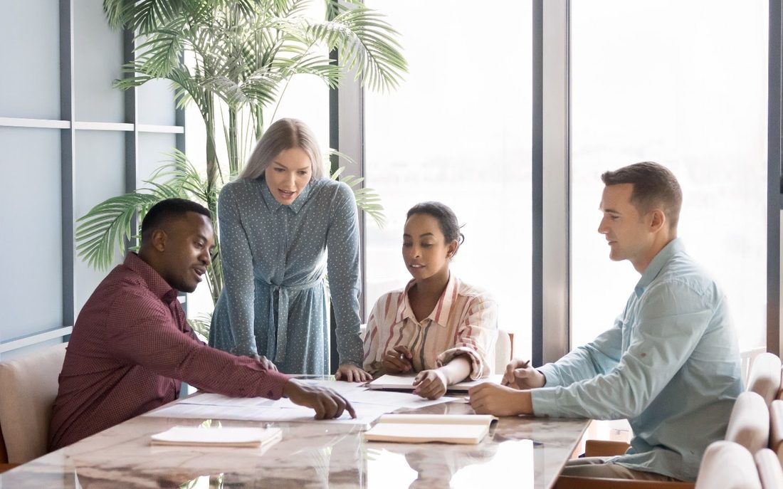 A consulting team reviewing documents around a conference table